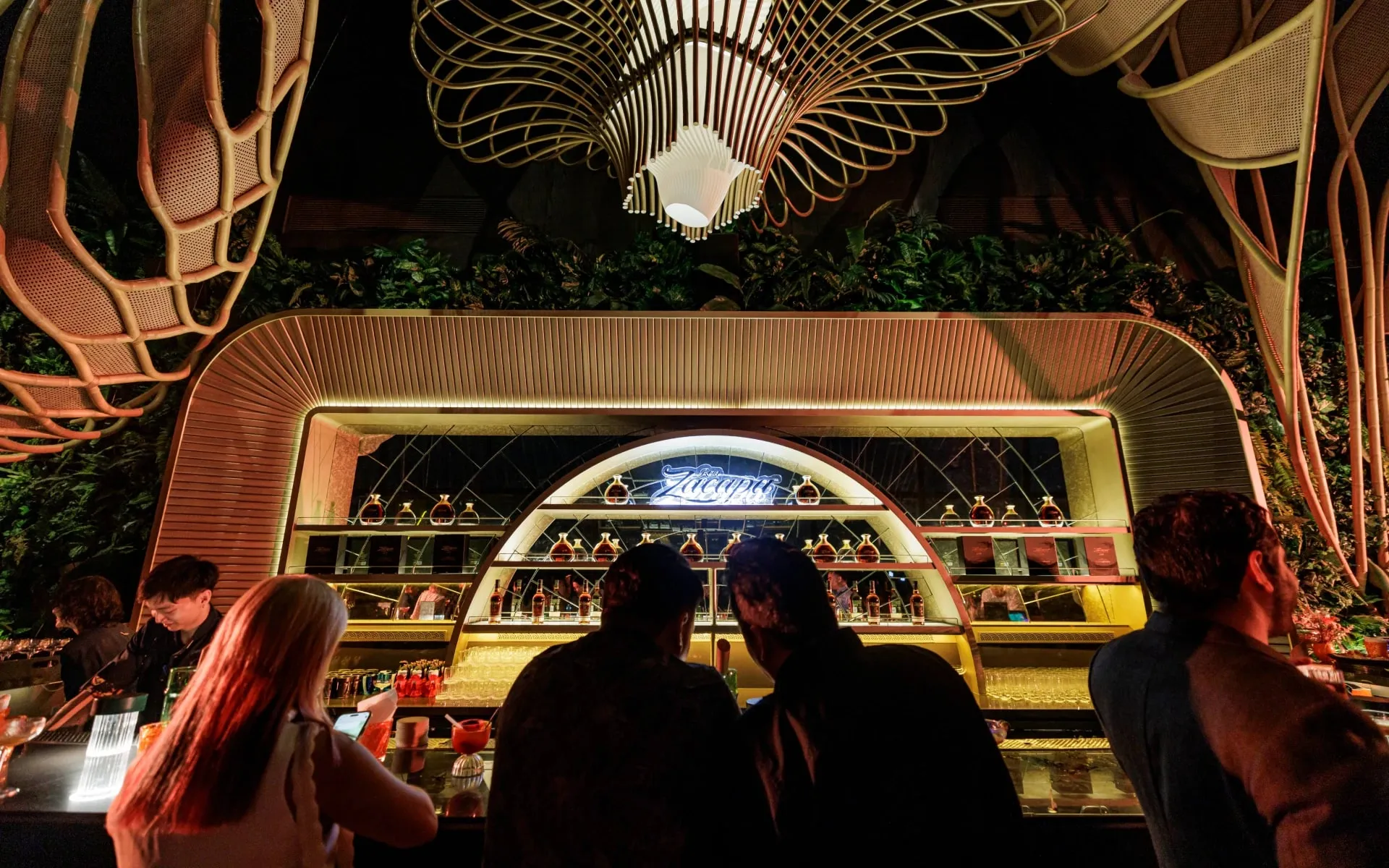 The Zacapa bar under a woven canopy, guests at the counter