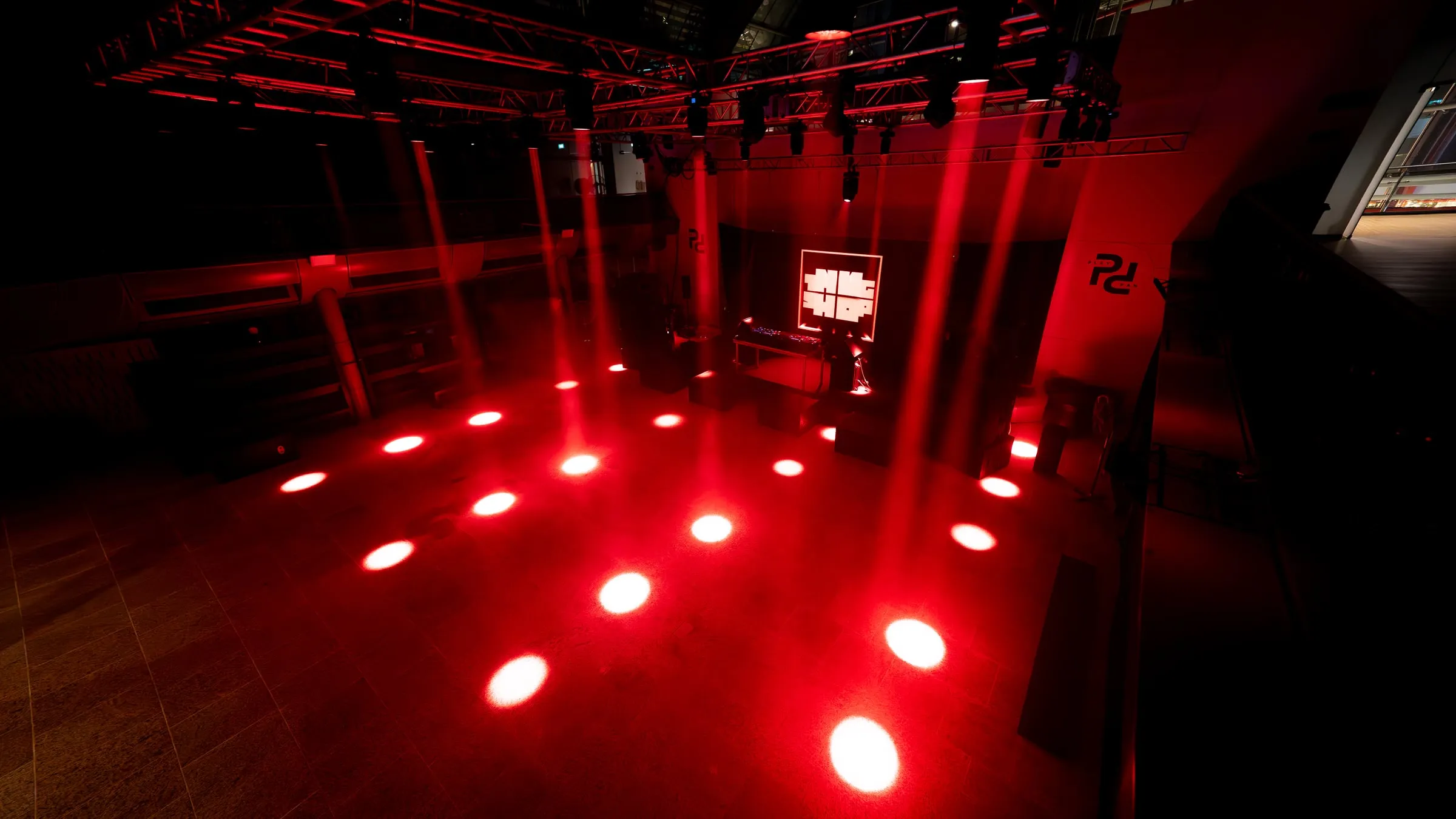 The empty room from the back, beams crossing over the floor