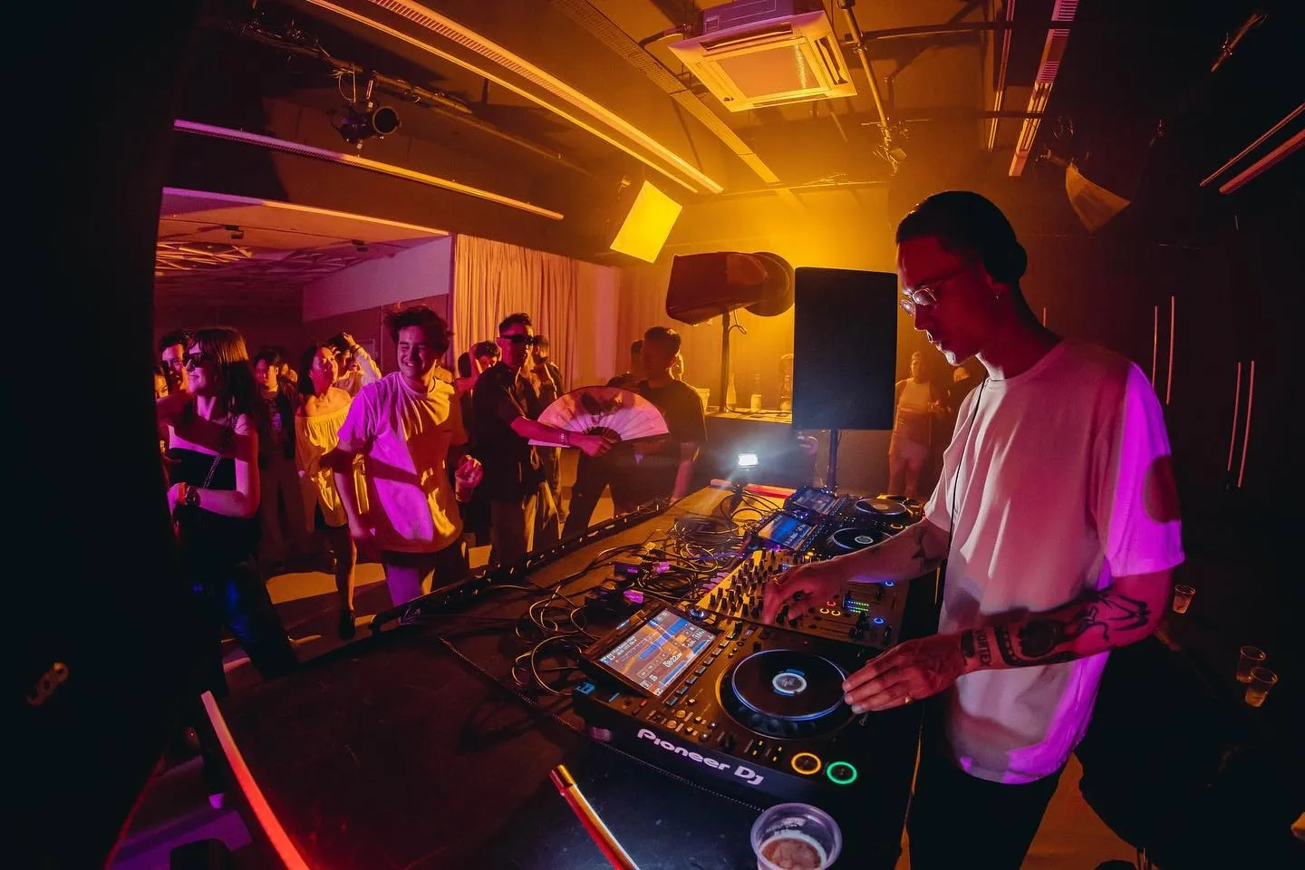 The DJ at the decks under the ceiling wash