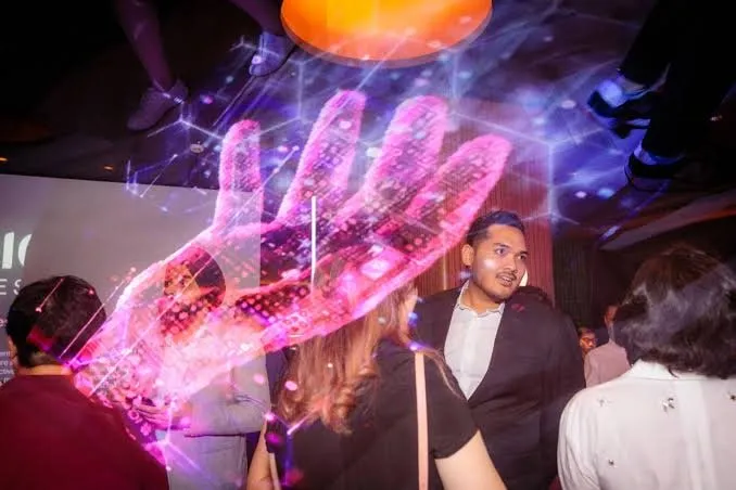A projected hand of light over the crowd