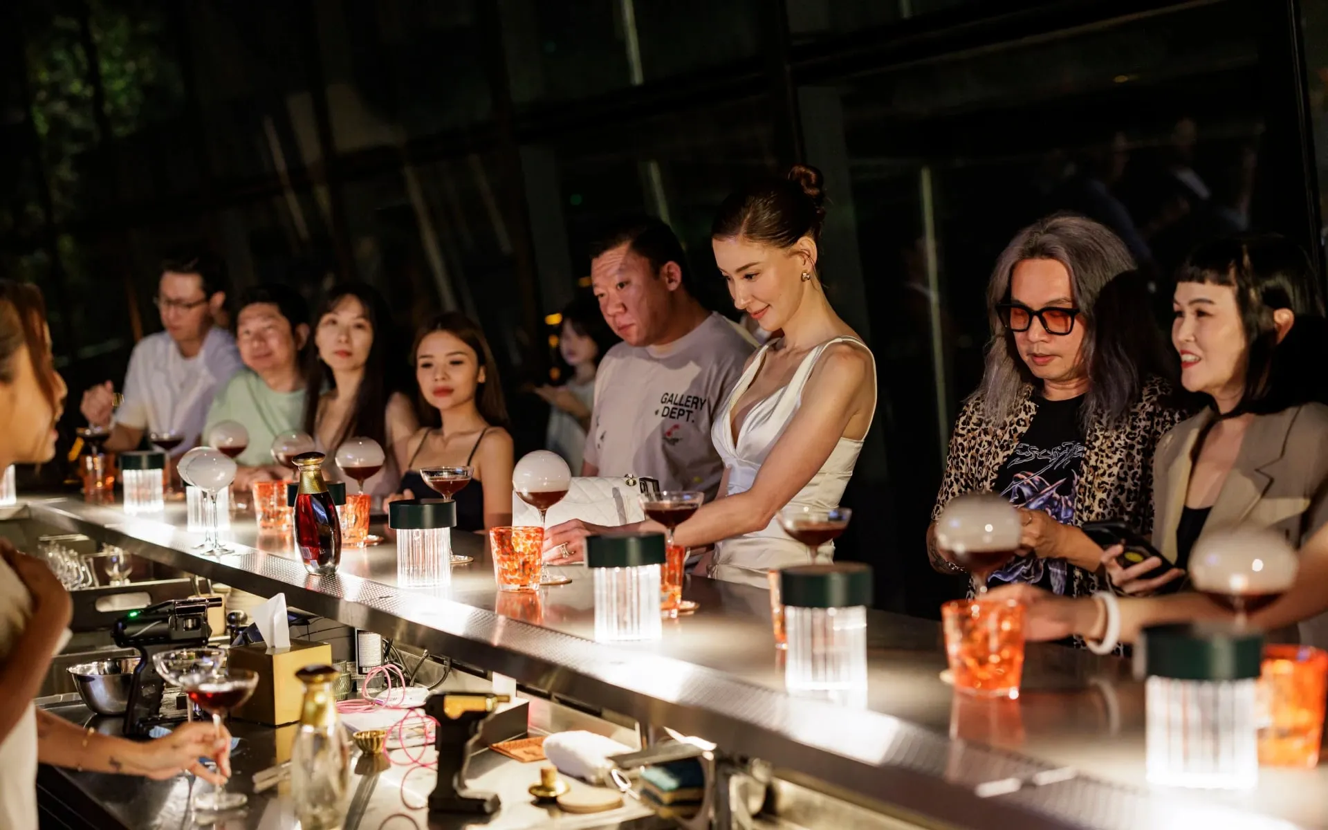 Guests at the tasting counter under low light